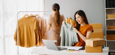 Moda blogcusu konsepti, internette kıyafet satan genç Asyalı kadın. Başlangıçta küçük işletme KME