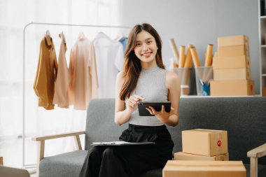 Moda blogcusu konsepti, internette kıyafet satan genç Asyalı kadın. Başlangıçta küçük işletme KME