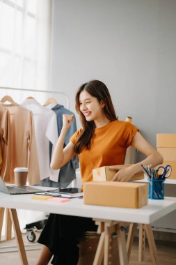 Moda blogcusu kavramı, genç Asyalı kadın video yayınında kıyafet satıyor. Tablet ve dizüstü bilgisayar kullanarak küçük işletme KOBİ 'si kurun.