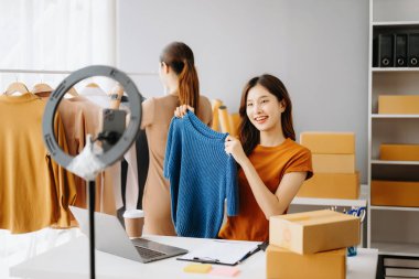 Moda blogcusu konsepti, internette kıyafet satan genç Asyalı kadın. Başlangıçta küçük işletme KME