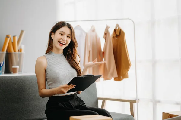 stock image Young business owner woman prepare parcel box and standing check online orders for deliver to customer on tablet, laptop Shopping Online concept