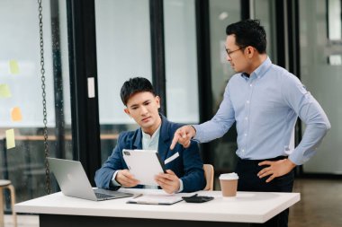Kızgın iki Asyalı işadamı işte hata yaptıktan sonra tartışıyor.
