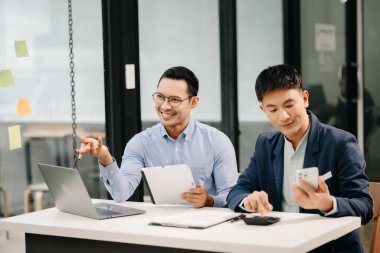 Modern ofiste birlikte çalışan iki Asyalı iş adamı. 