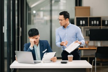 Kızgın iki Asyalı işadamı işte hata yaptıktan sonra tartışıyor.