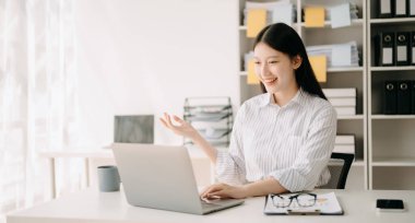 Genç Asyalı iş kadını mesleki başarısından dolayı heyecanlanıyor. Neşeli kadın ofiste kazananın jestini yapıyor. 