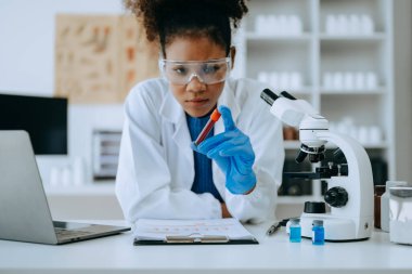 Modern tıbbi araştırma laboratuvarı. Kadın bilim adamı mikro pipetlerle biyokimyasal örnekleri analiz ediyor.