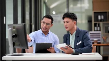 İki Asyalı işadamı ofiste yatırım projesini tartışıyor