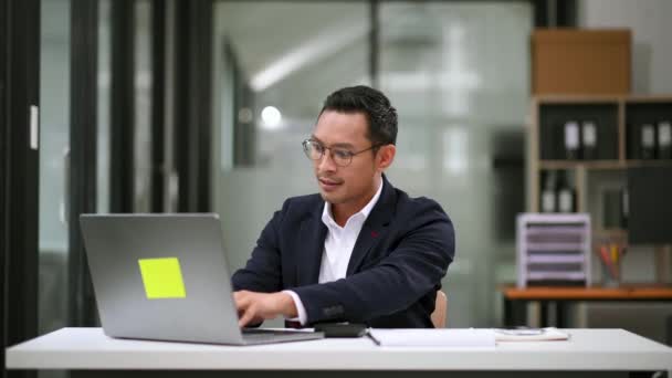 現代のオフィスでラップトップを使用する若いアジアのビジネスマン 自信のあるホワイトカラー労働者 — ストック動画