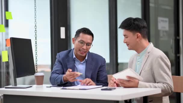 オフィスで投資プロジェクトを議論する2人のアジアのビジネスマン — ストック動画