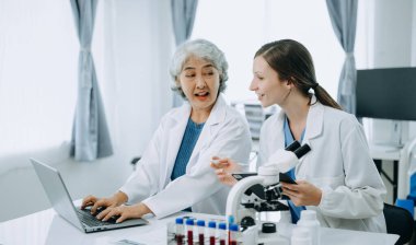 Laboratuvarda online okuma, test örnekleri ve yenilikler ile tıbbi bir görüşme yapan iki bilim adamı veya tıbbi teknisyen