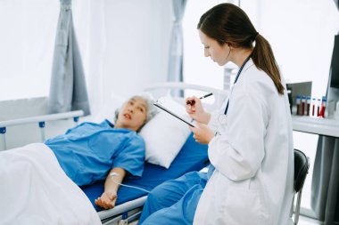 Doktor ve hasta modern klinikte ya da hastanede muayene yatağındayken bir şey tartışıyorlar. İlaç ve sağlık hizmetleri kavramı