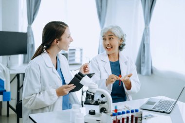 Laboratuvarda online okuma, test örnekleri ve yenilikler ile tıbbi bir görüşme yapan iki bilim adamı veya tıbbi teknisyen