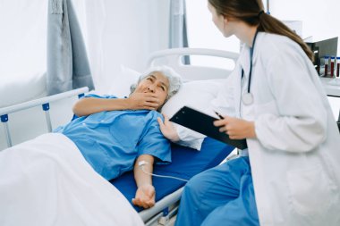 Doktor ve hasta modern klinikte ya da hastanede muayene yatağındayken bir şey tartışıyorlar. İlaç ve sağlık hizmetleri kavramı