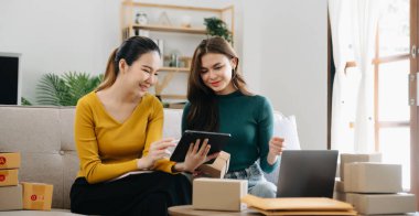 Küçük işletmeler kuran KOBİ sahipleri ürün satıyor, ev ofisinde kutularla çalışıyor, tablet ve dizüstü bilgisayar kullanıyor