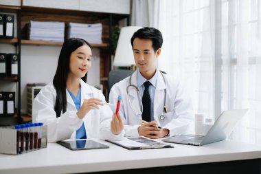 Tıp teknolojisi ekip toplantısı konsepti. Tıp endüstrisinde, grafik arayüzü ile dijital tablet üzerinde çalışan Asyalı doktorlar