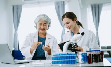 Laboratuvarda online okuma, test örnekleri ve yenilikler ile tıbbi bir görüşme yapan iki bilim adamı veya tıbbi teknisyen