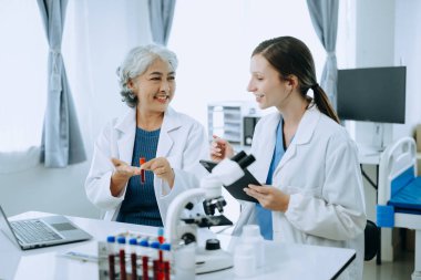 Laboratuvarda online okuma, test örnekleri ve yenilikler ile tıbbi bir görüşme yapan iki bilim adamı veya tıbbi teknisyen