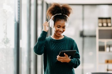 Modern üniversite kütüphanesinde online okuyan mutlu genç Afrikalı kız öğrenci