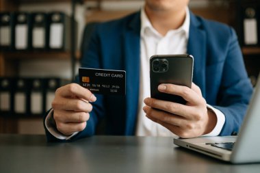 Mobil ödeme online alışveriş, omni kanal, masada oturan, sanal simgeleri grafik arayüzü ekran sabah ışık için akıllı telefon kullanan adam