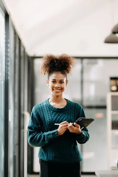 stock image happy young African female student studying online in modern college library