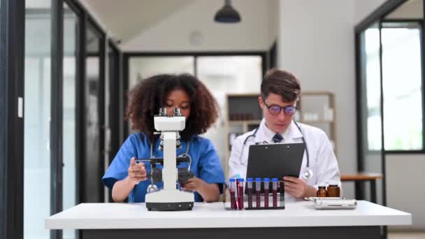 Лаборатория Современных Медицинских Исследований Портрет Двух Ученых Работающих Использующих Микроскоп — стоковое видео