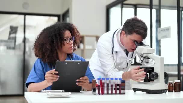 Лаборатория Современных Медицинских Исследований Портрет Двух Ученых Работающих Использующих Микроскоп — стоковое видео
