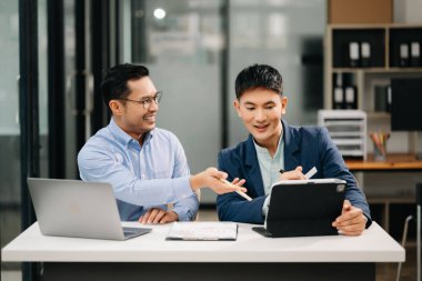 Modern ofiste çalışan iki Asyalı iş adamı..