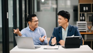 Modern ofiste çalışan iki Asyalı iş adamı..