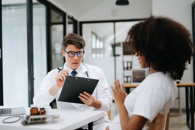 Olgun doktor ve hasta masada otururken bir şey tartışıyorlar. İlaç ve sağlık hizmetleri kavramı.