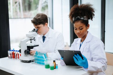 Yetişkin erkek doktor ve Afrikalı kadın hemşire birlikte anesteziyi tartıştılar. Hastanedeki çeşitli tıp uzmanları...