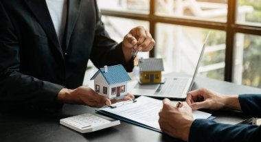Emlakçı yeni evi müşteriye sunuyor. İpotek kredisine danışmanlık yapan komisyoncu