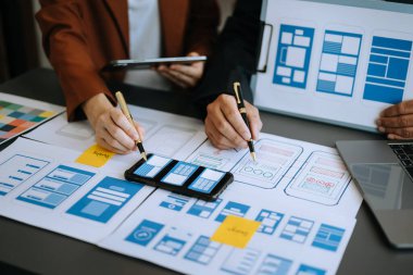 UX geliştiricisi ve ui tasarımcısı modern ofiste renk kodlu mobil uygulama arayüzü tasarımı. 