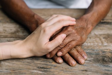 Hands of the old man and a woman hands close up.