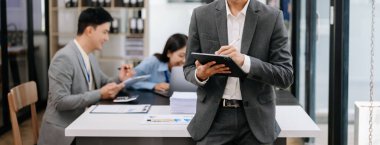 Genç Asyalı iş adamları modern ofiste çalışıyor.