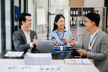 Genç Asyalı iş adamları modern ofiste çalışıyor.