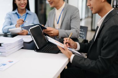Genç Asyalı iş adamları modern ofiste çalışıyor.