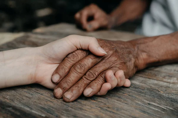 Hands of the old man and a woman hands close up.