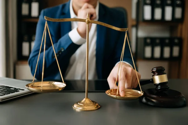 Male lawyer in the office with brass scale on wooden table. justice and law concept in morning ligh