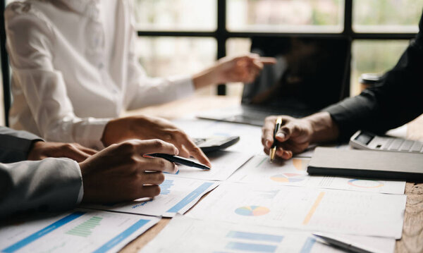 Команда бизнесменов анализирует графики. Концепция управления капиталом в офисе