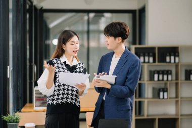 Ana ofiste tablet kullanan iki Asyalı iş adamı.