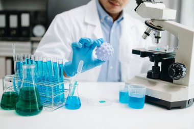 Erkek biyoteknoloji uzmanı laboratuvarda yeni kimyasal maddeler test ediyor. Biyokimyasal örnekleri analiz eden mikro pipetlerle tıp için ileri bilim kimya laboratuvarı.