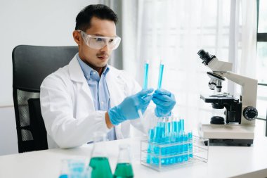 Modern tıbbi araştırma laboratuvarı. Mikro pipetlerle çalışan erkek bilim adamı biyokimyasal örnekleri analiz ediyor, tıp için gelişmiş kimya laboratuvarı.