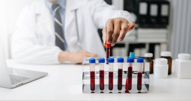 Tıp laboratuarında araştırma yapan genç bir bilim adamı, test tüpleriyle çalışan bir araştırmacı. 