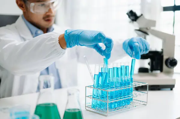 Male biotechnologist testing new chemical substances in a laboratory. with micro pipettes analyzing biochemical samples, advanced science chemical laboratory for medicine.