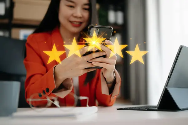 Customer or client the stars to complete five stars. with copy space. giving a five star rating. Service rating, satisfaction concept. working woman in the office with smartphone