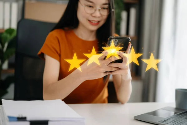 Customer or client the stars to complete five stars with copy space. giving a five star rating. Service rating, satisfaction concept. working woman with smartphone in the office