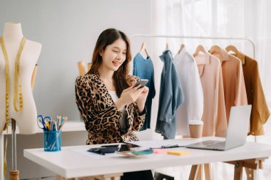Başarılı bir moda tasarımcısı. Çekici genç Asyalı kadın stüdyoda terzi olarak çalışıyor.
