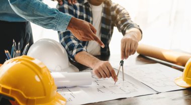 Modern şehirdeki yeni inşaat projesinde birlikte çalışan mühendislerden oluşan bir ekip. Ayrıntılı planlar