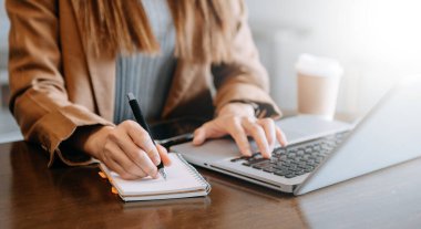 Yeni modern bilgisayarla çalışan ve ofiste not alan bir iş kadını. 