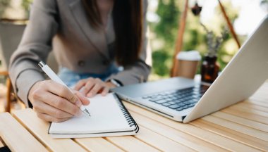 Dizüstü bilgisayar kullanan bir iş kadını. Bulanık arkaplanda yakın plan